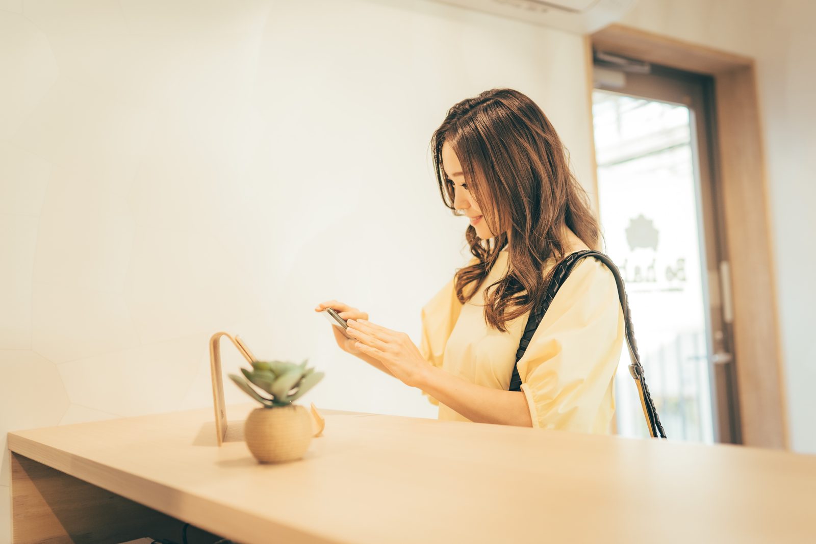 受付でカウンセリングシートに記入する女性
