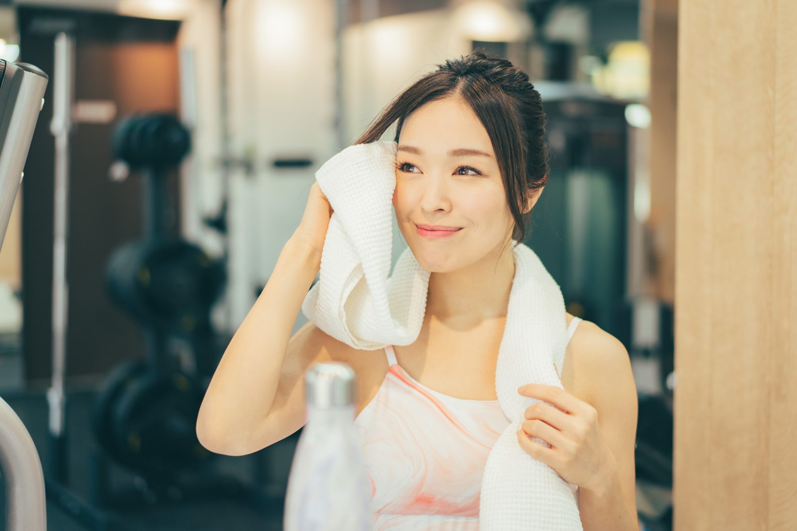タオルで汗を拭きながらひと休みする女性